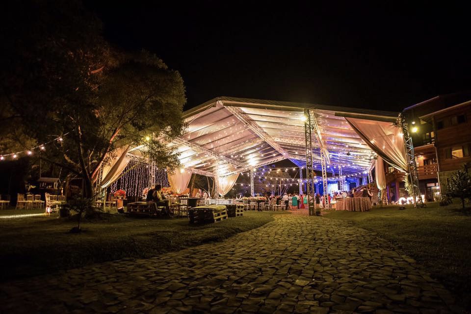 Estrutura de evento corporativo com palco, iluminação cênica e cadeiras dispostas — Mani Som & Luz